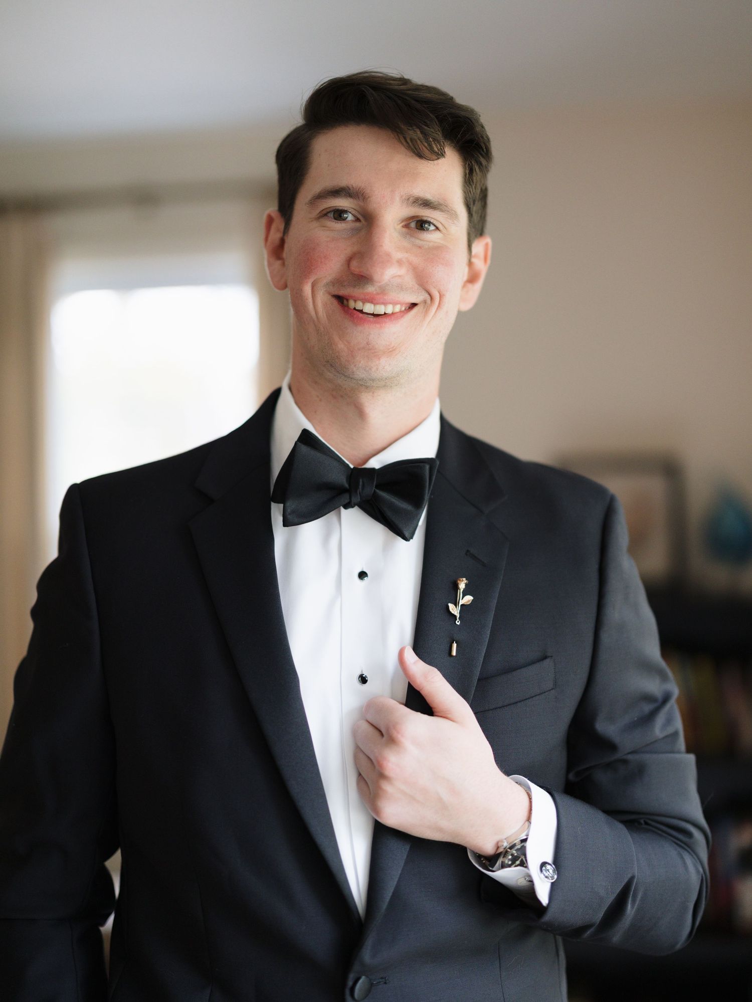 A series of formal portraits showing details of a groom adjusting his black tuxedo and bow tie.