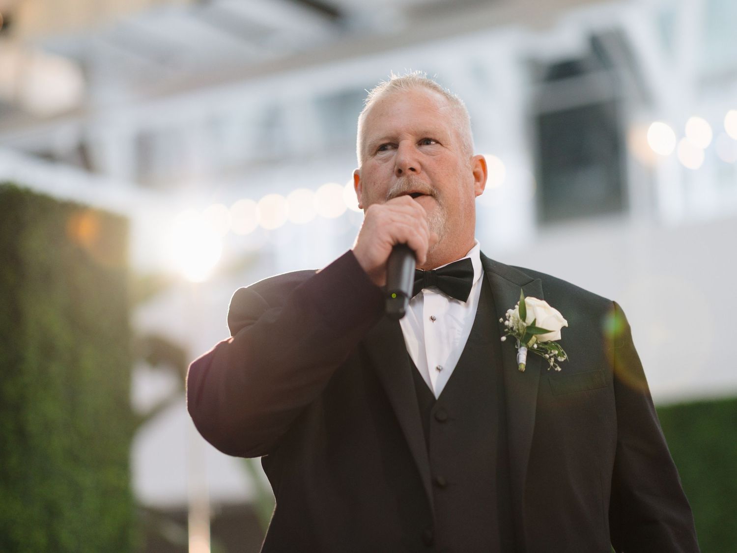 Close-up shots of men in black tuxedos during formal wedding celebration.