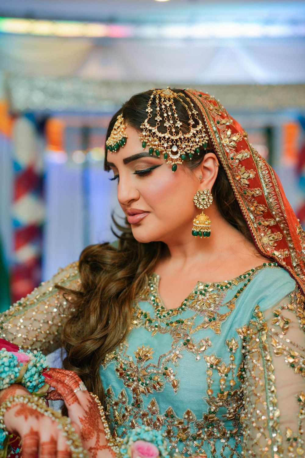 Beautiful Pakistani bridal jewelry and makeup featuring intricate gold headpiece and turquoise embellished dress.