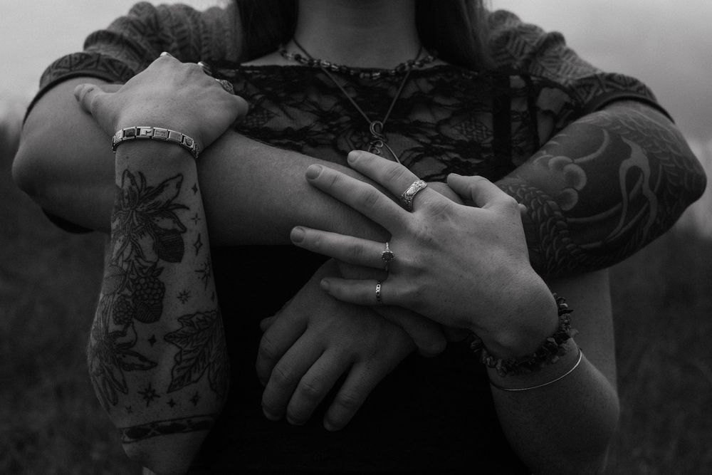 Black and white photo of hands holding a camera lens with a blurred background.