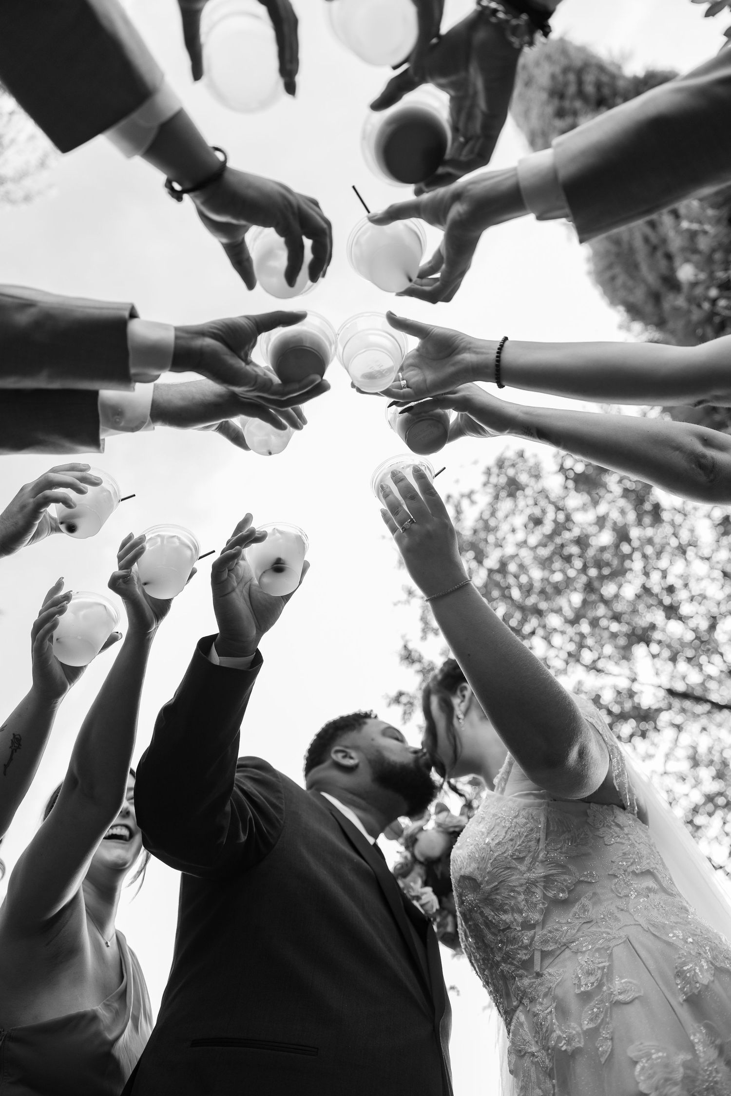 Black and white photo of wedding guests tossing confetti in celebration.