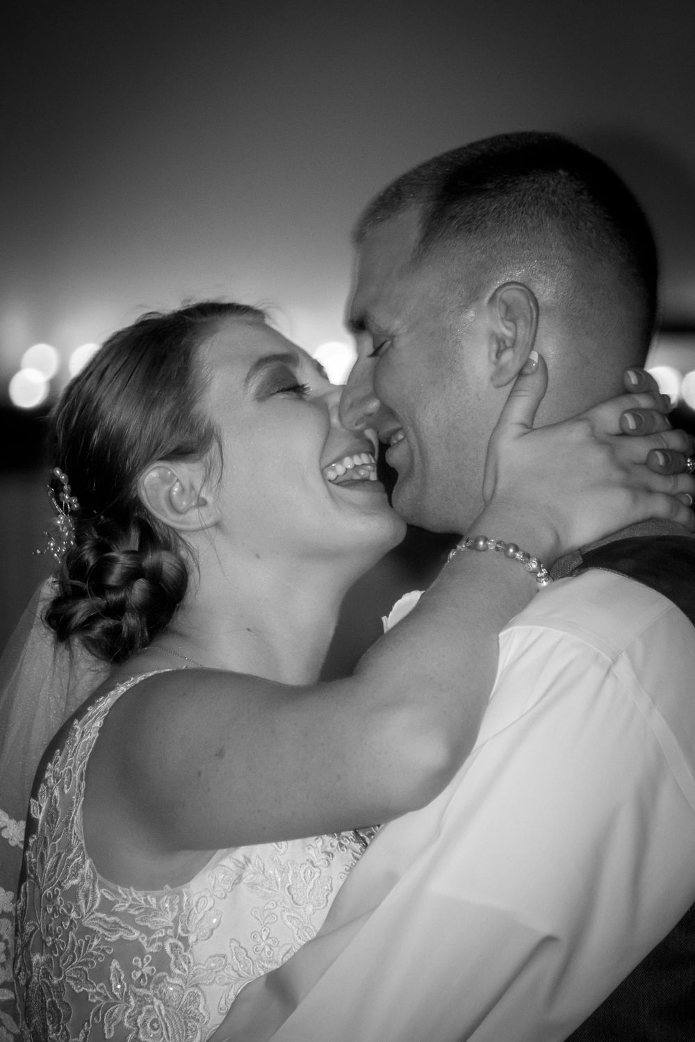A bride and groom share a romantic kiss during their enchanting first dance at their wedding celebration.
