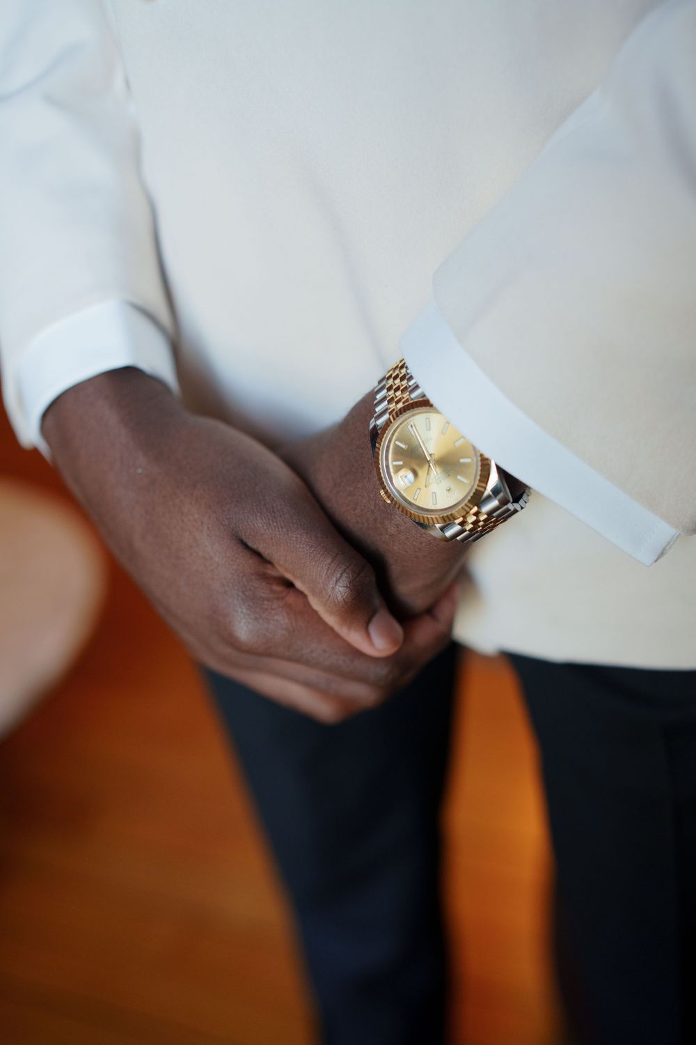 Close-up shots of a gold watch on someone's wrist shown from different angles against a white and orange background.