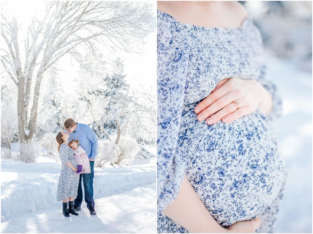 A snowy winter scene featuring an intimate maternity photoshoot with a couple in blue floral attire.
