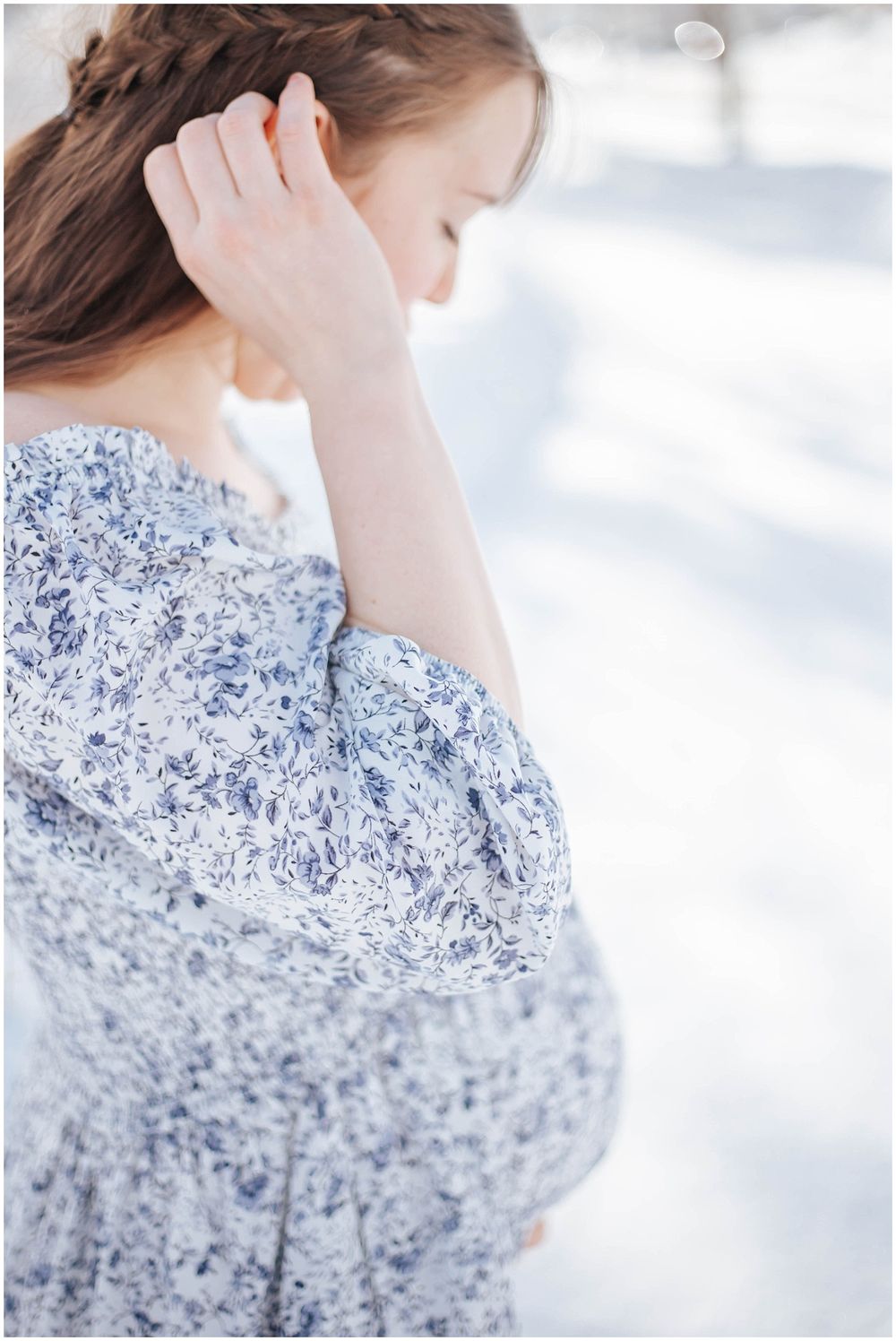 Side view of someone in a delicate blue floral dress against a soft white background.