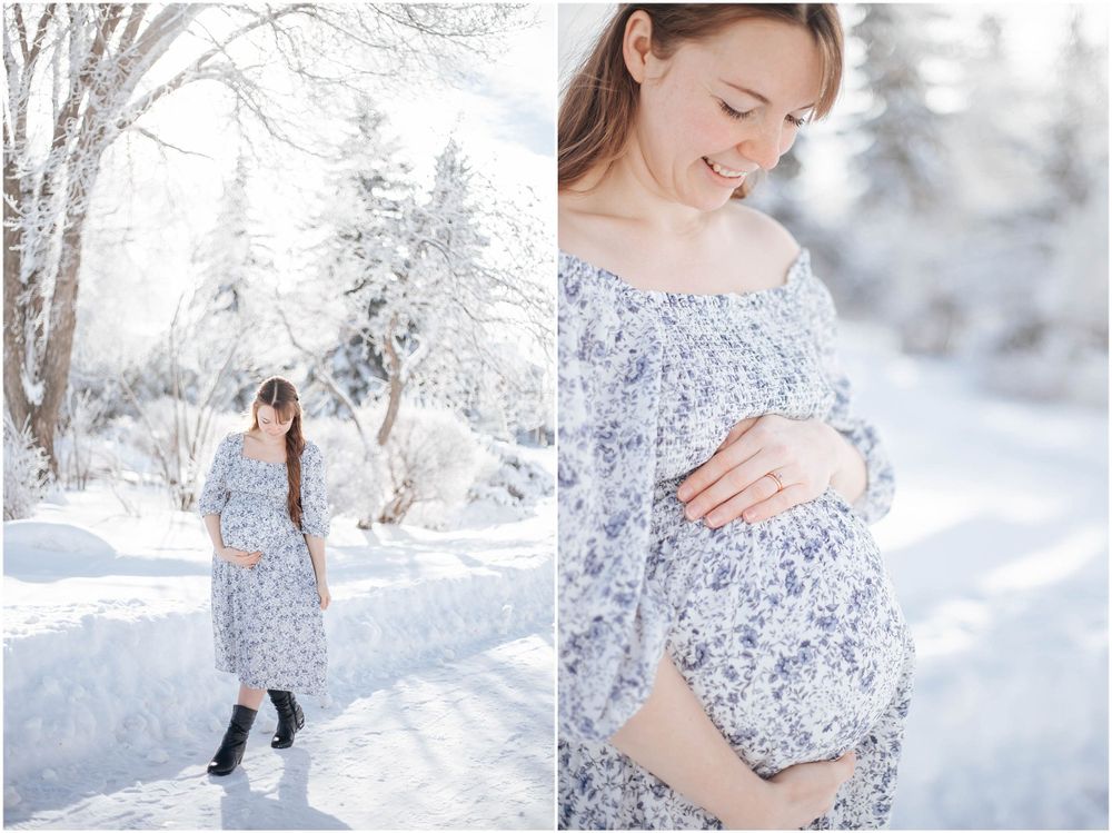 Person in a floral off-shoulder dress poses in a snowy winter landscape while cradling their belly.