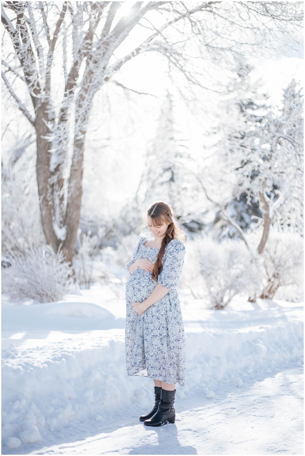 A floral dress-clad figure stands in a serene winter landscape with snow-covered trees and bright white surroundings.
