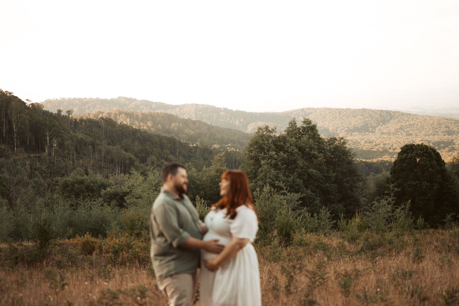Romantic maternity couple portrait in golden hour vineyard setting