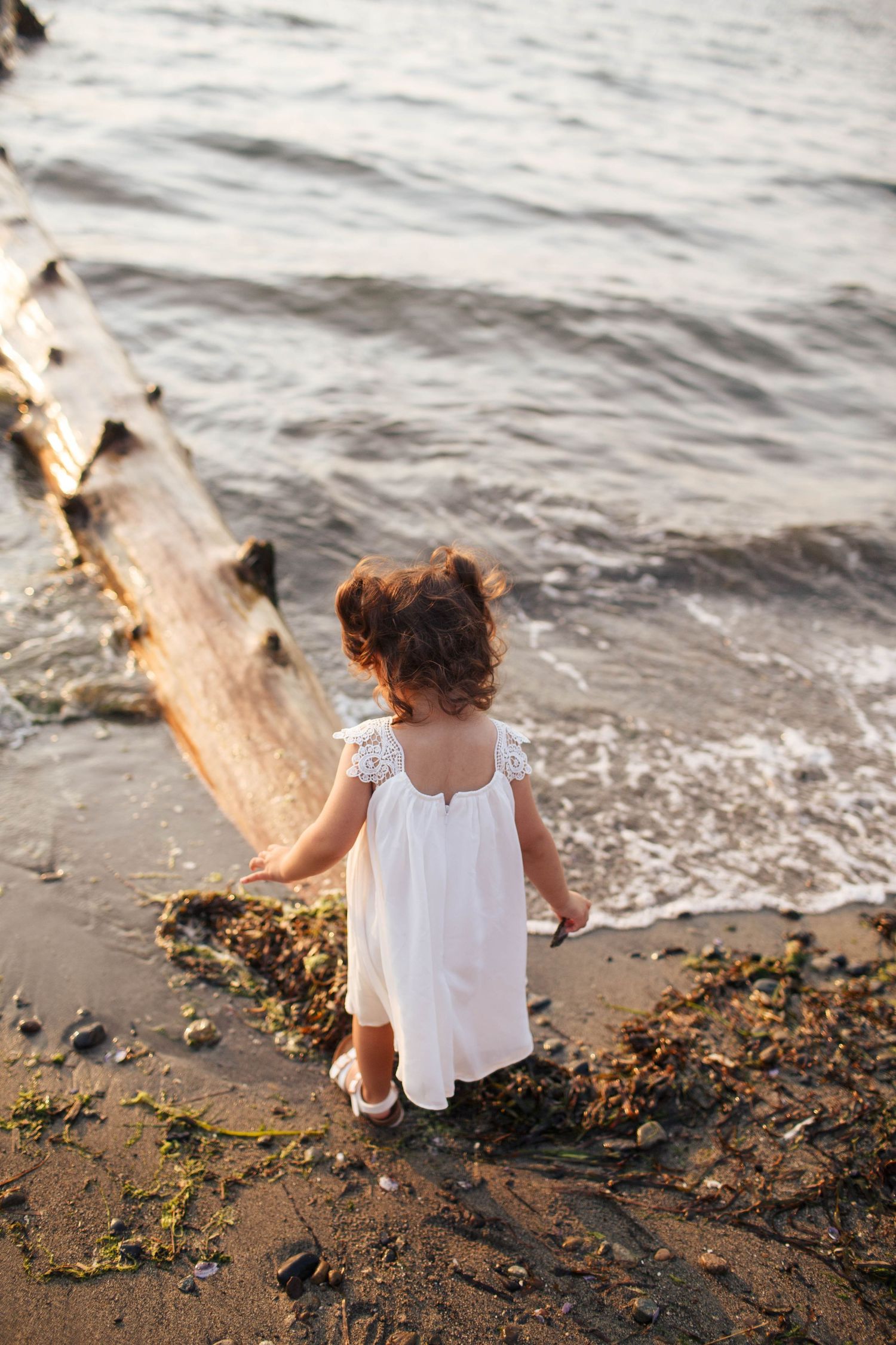 Everett WA family photographer: a young girl plays near the shore at Howarth Park in Everett WA