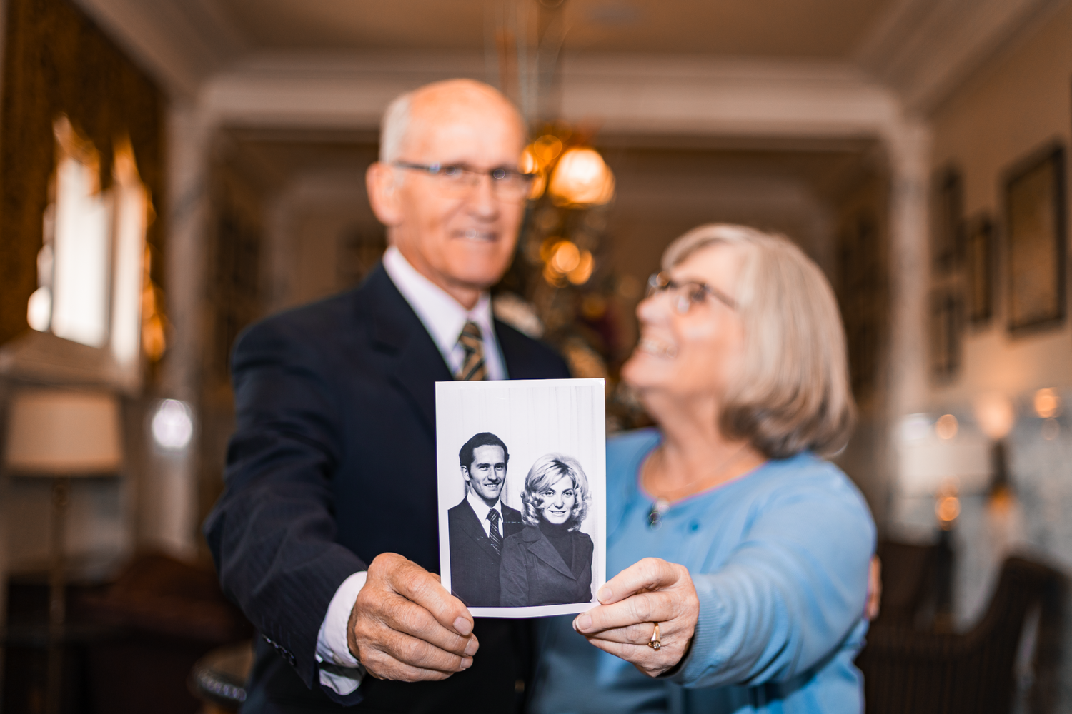 Portrait of older couple holding photo of them after their marriage