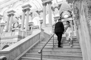Black and white wedding photos on grand architectural staircase.