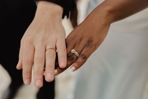 Close-up of wedding rings on hands of a newly married couple.