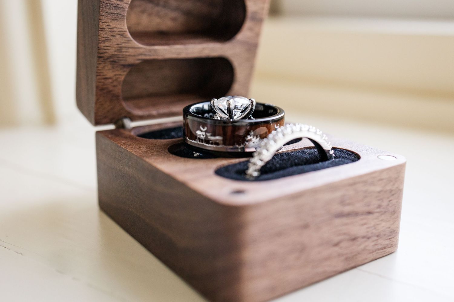 Wedding rings displayed in an elegant wooden ring box.