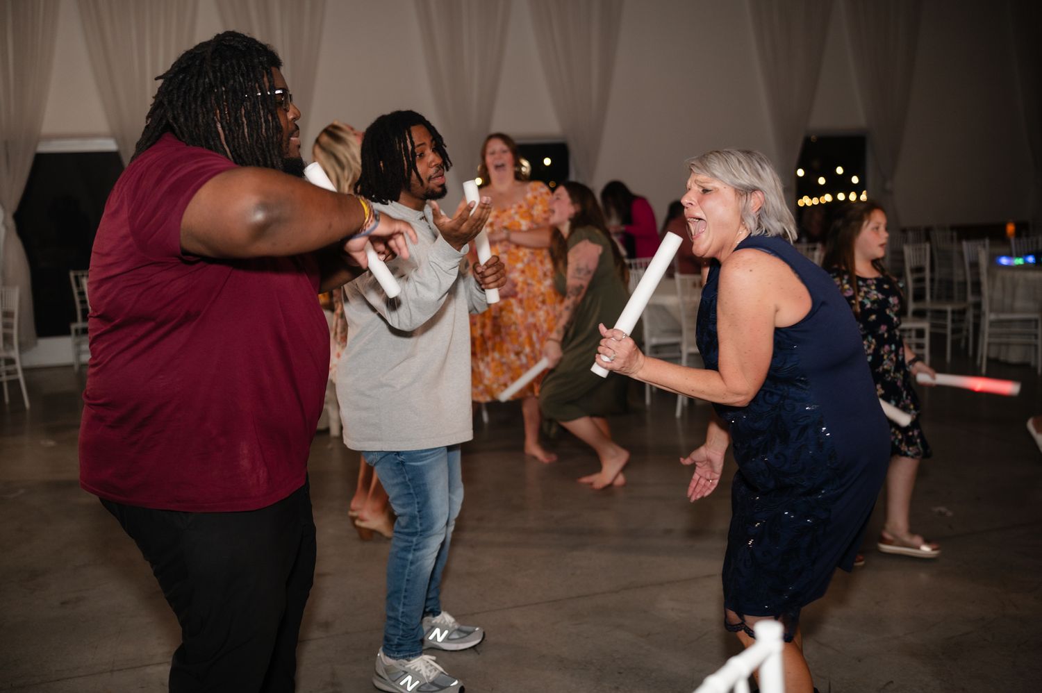 Lively dance party scene with guests enjoying themselves at a wedding reception.
