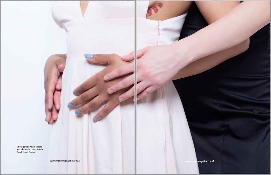 Close-up of hands grasping a white dress against a light background.