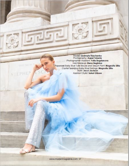 Fashion editorial featuring flowing blue tulle gown on classical architectural steps.