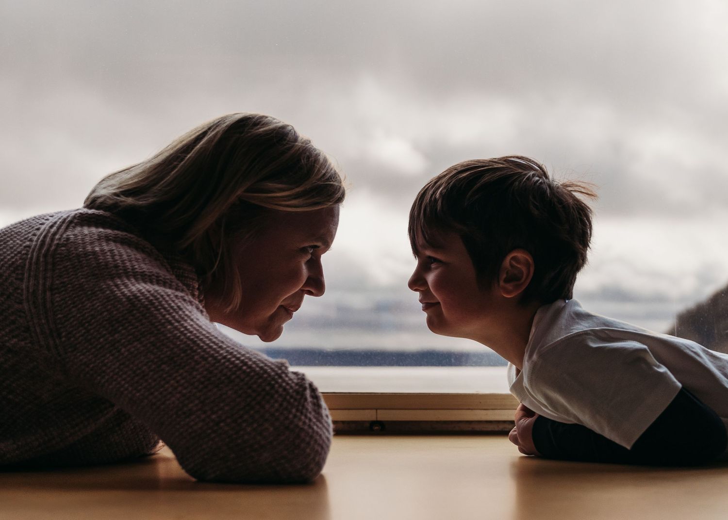 An intimate moment of connection across a wooden table surface.