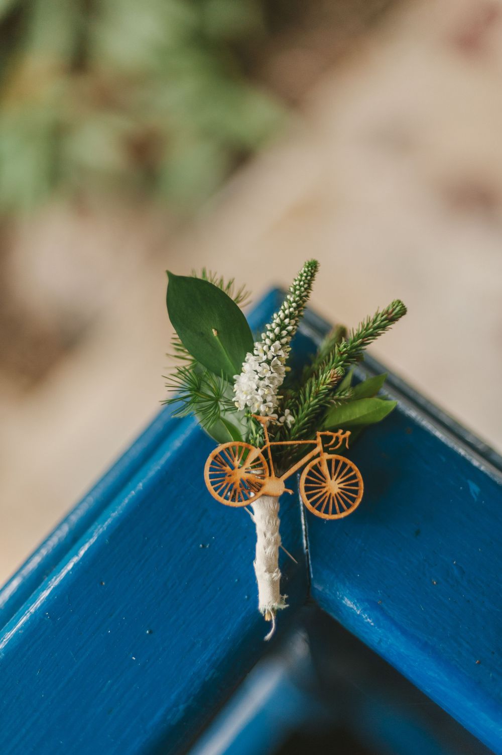 Detail of the groom's boutonniere that includes a miniature wood bicycle.