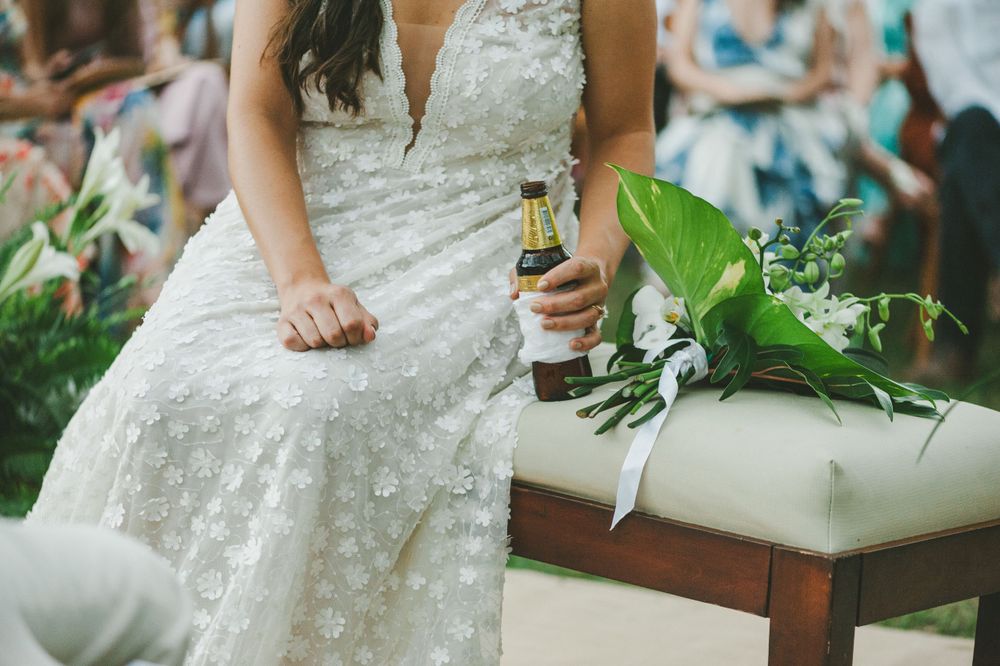 Bride holding a bottle of beer during wedding ceremony in Colombia.