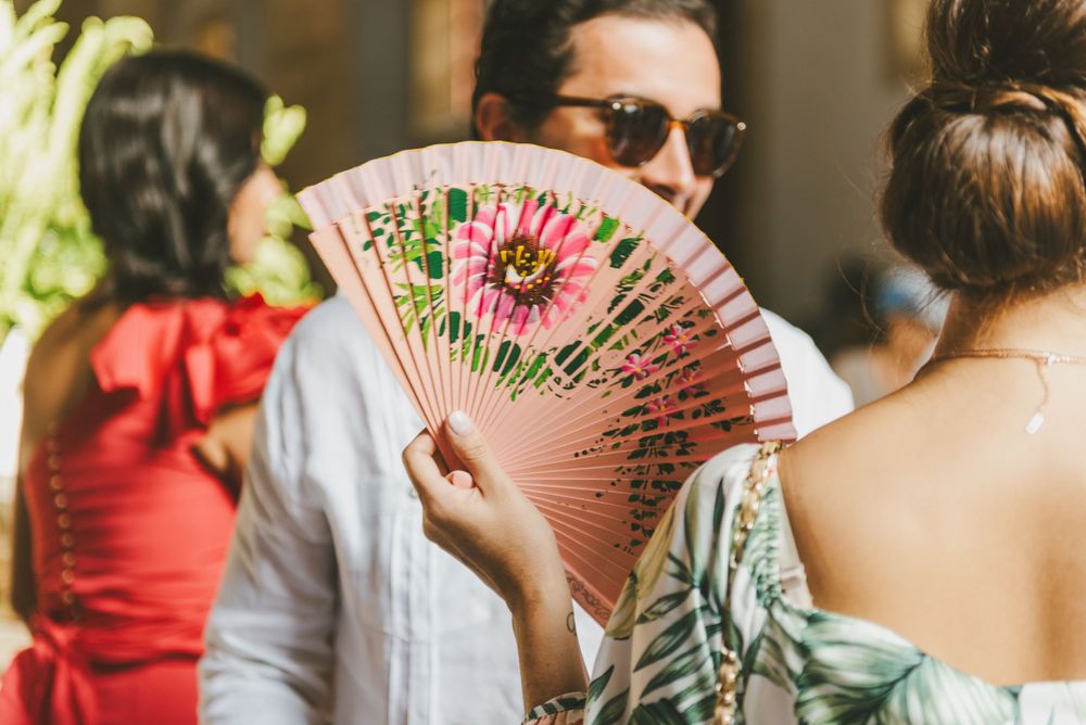 Wedding guest holding a traditional Colombian fan in Cartagena.