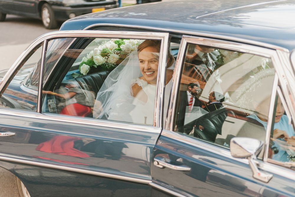 Bride arrives at her wedding ceremony riding a vintage car.