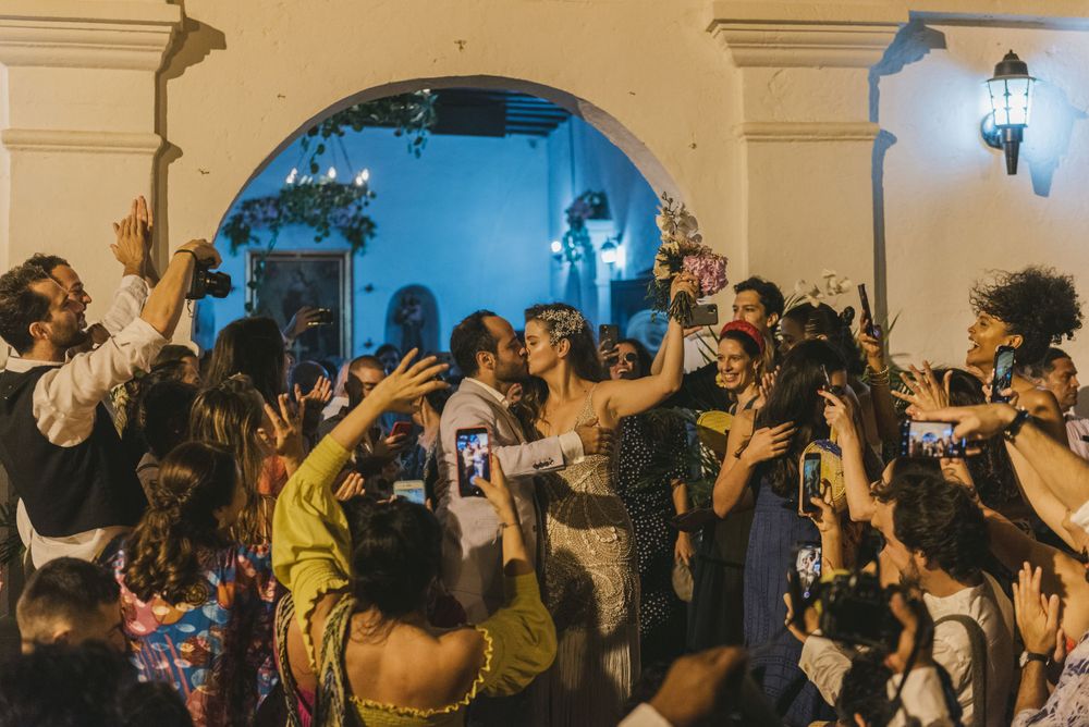 Newlyweds and wedding guests cheering outside of a Colombian church.