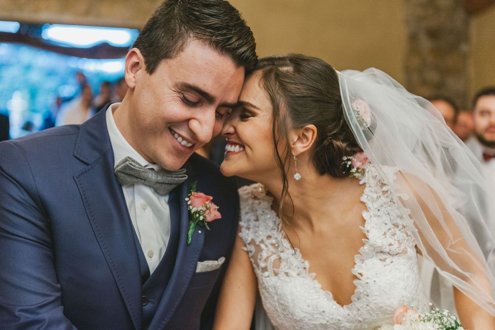 Bride lovingly rubbing her nose on the groom's cheek during ceremony.