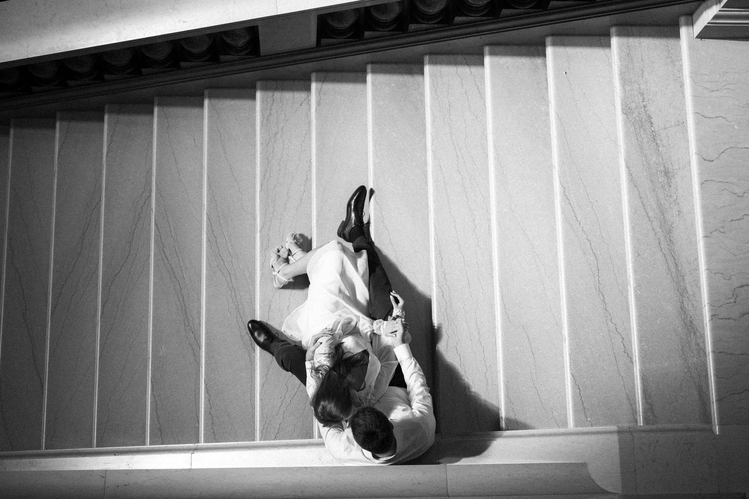 Black and white aerial view of someone climbing stairs from an artistic overhead perspective.