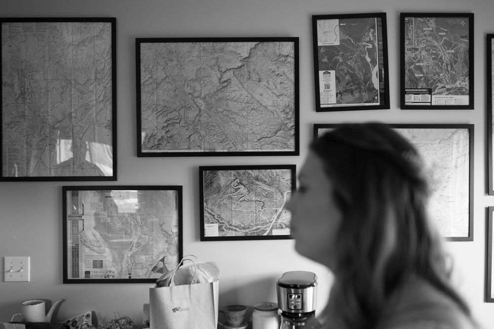 Interior wall decorated with framed maps in black and white.
