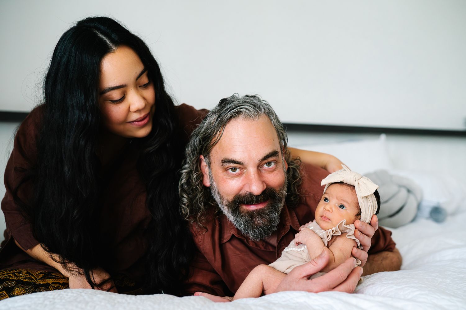 Parents with their newborn during a newborn and family photoshoot at home by Melbourne newborn and family photographer Pei A Photography