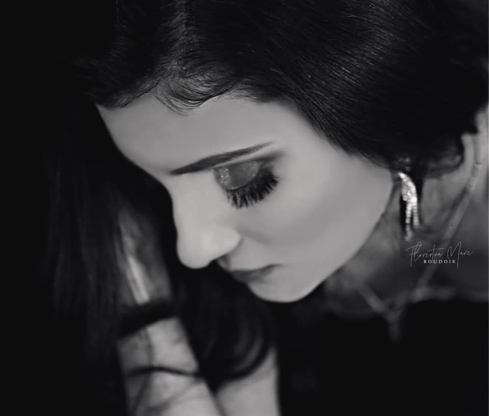 Artistic black and white portrait highlighting long eyelashes and delicate features.