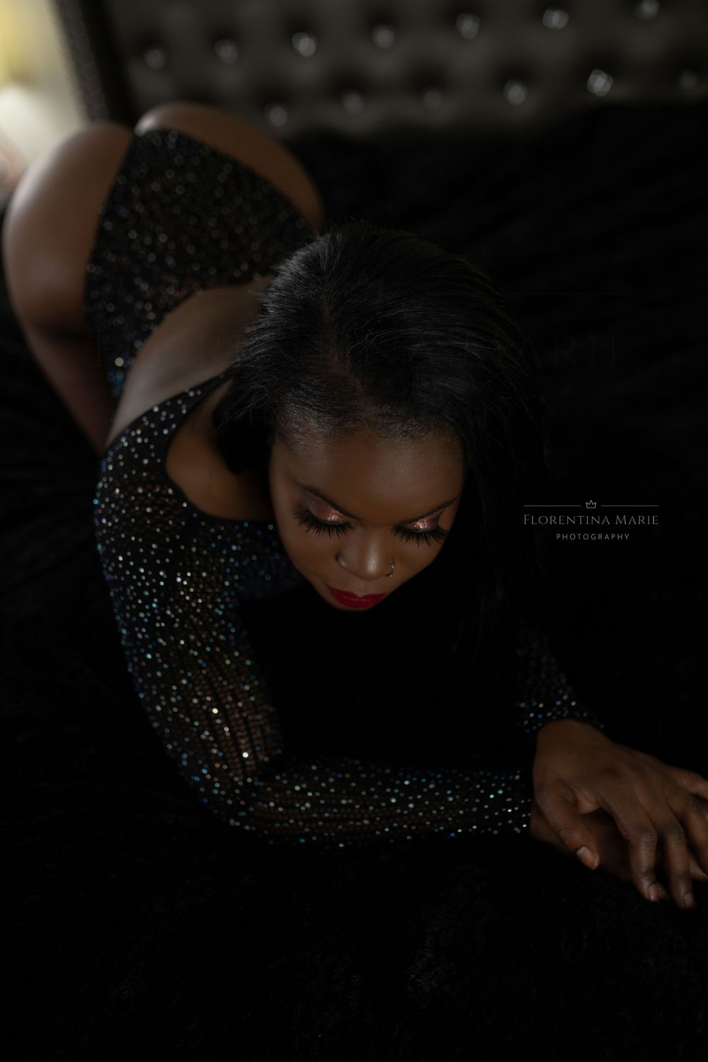 Artistic portrait featuring sparkly black dress and bold red lipstick in low-key lighting.