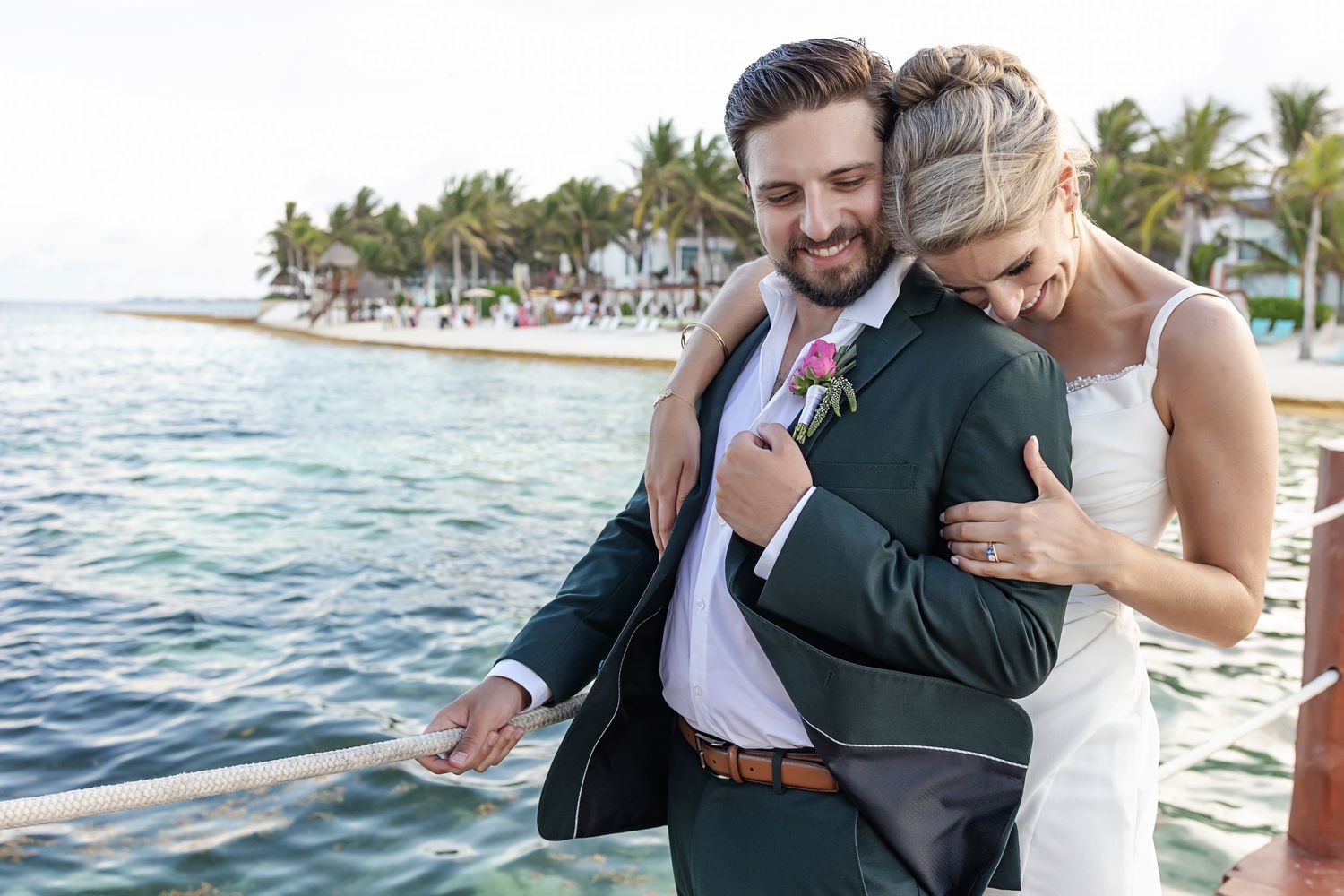 Groom smiles at bride holding a colorful tropical bouquet at Margaritaville Riviera Cancun wedding in the Riviera Maya.