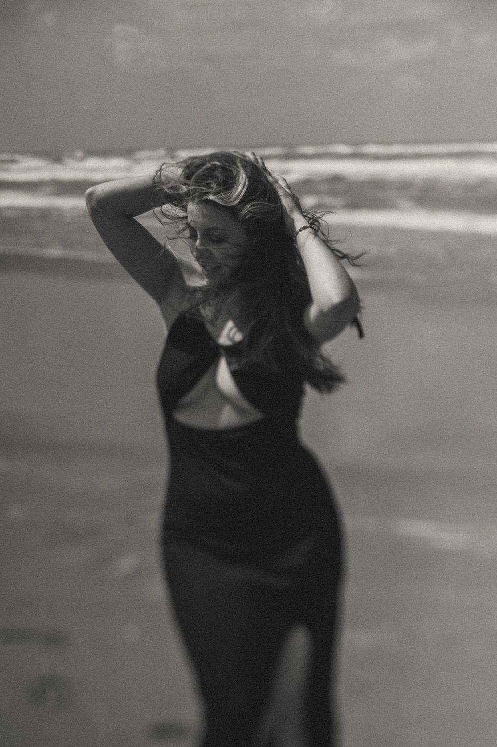 Dynamic sequence of a person in black moving against an ocean backdrop.