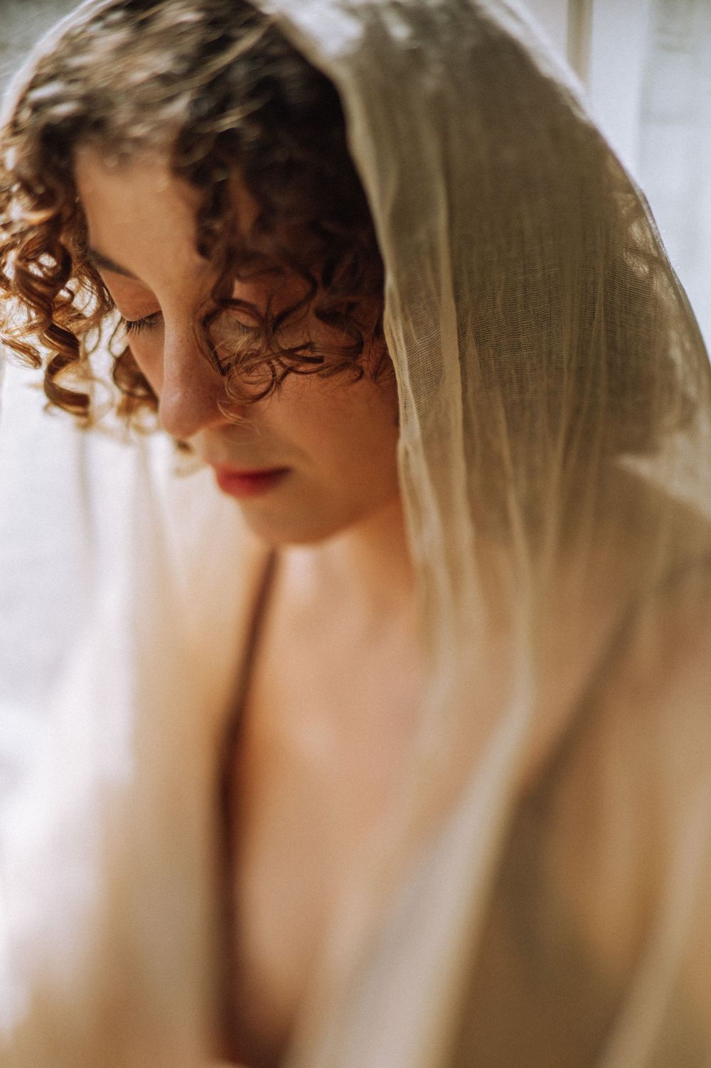 Artistic boudoir photography with soft focus and delicate lighting creating a romantic mood.