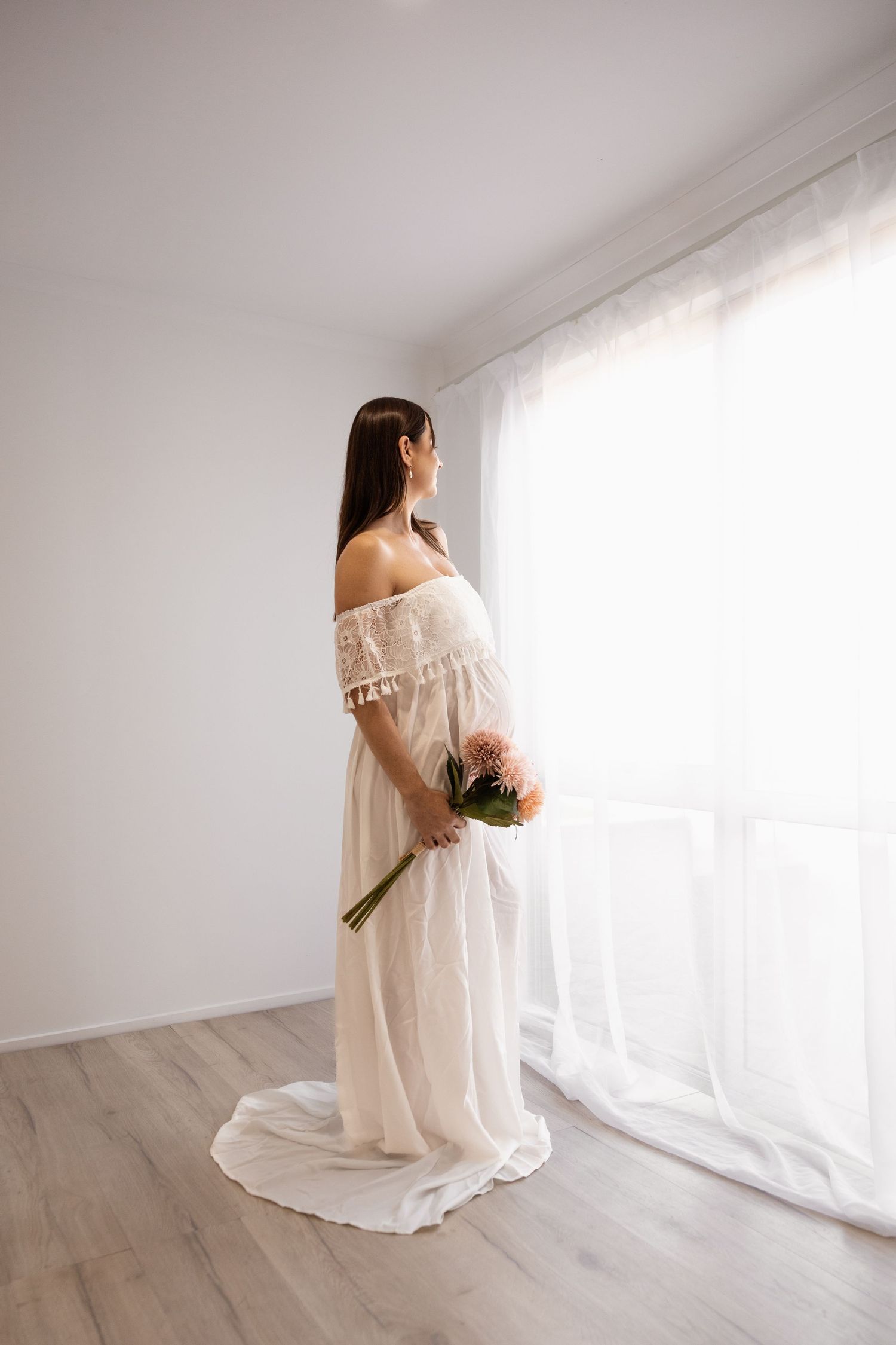 Pregnant mother looking down at her bump during maternity photoshoot