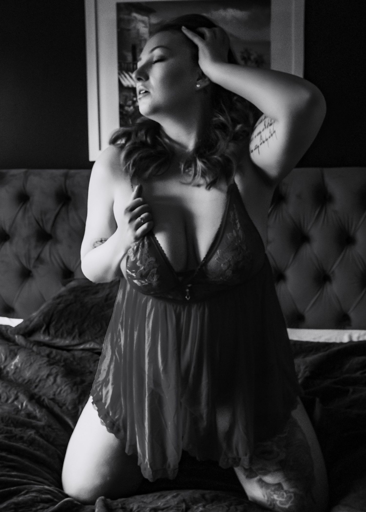Artistic black and white boudoir photo series showing sensual poses on tufted furniture.