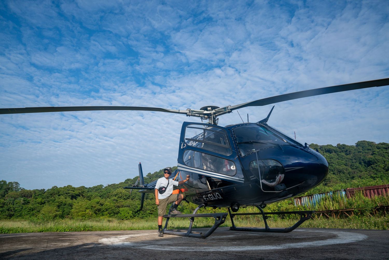Hélicoptère sur une hélisurface entourée de forêt en Guyane