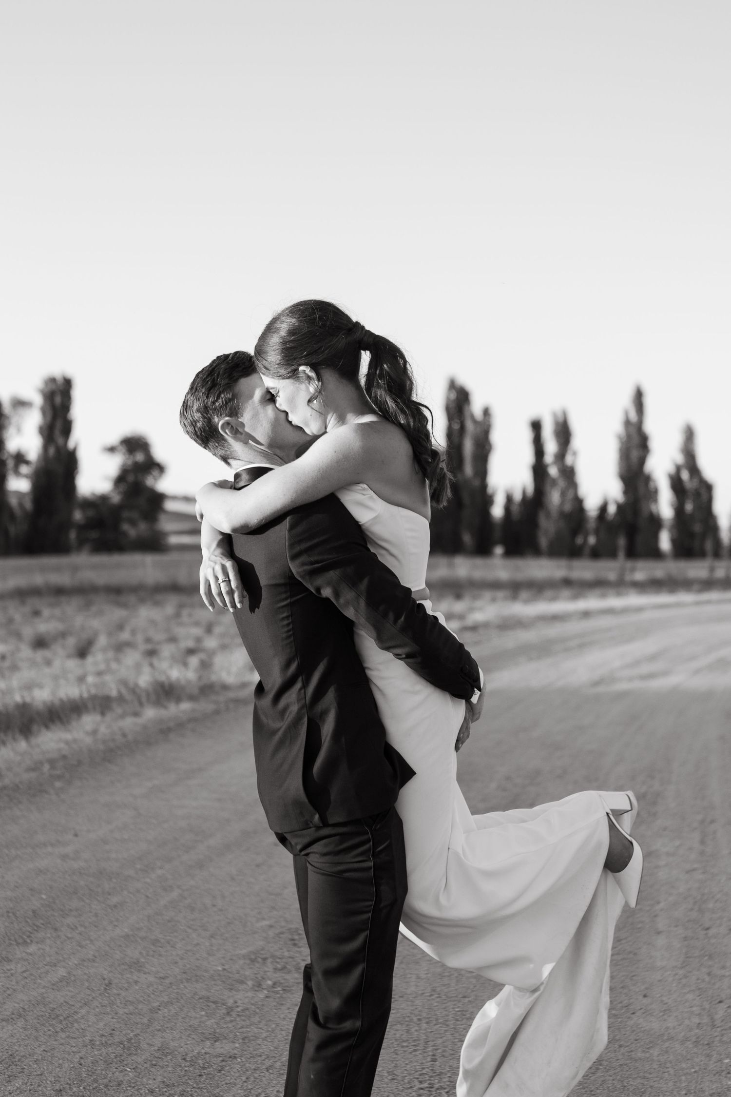 Bride and groom kissing while lifting up bride at NSW Country wedding