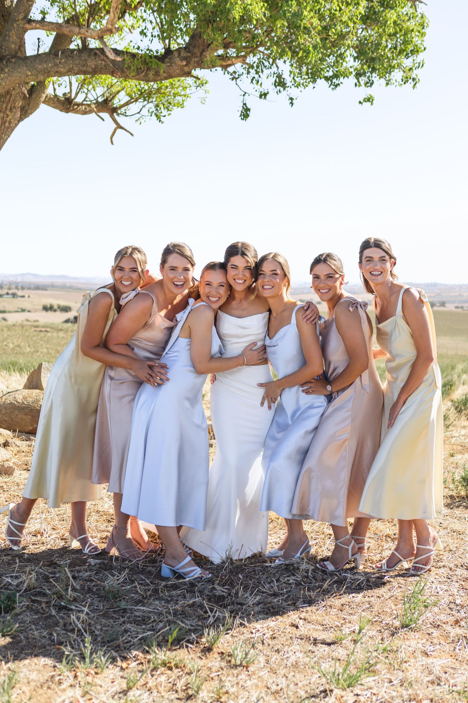 bridesmaids and bride hugging underneath tree at country NSW wedding