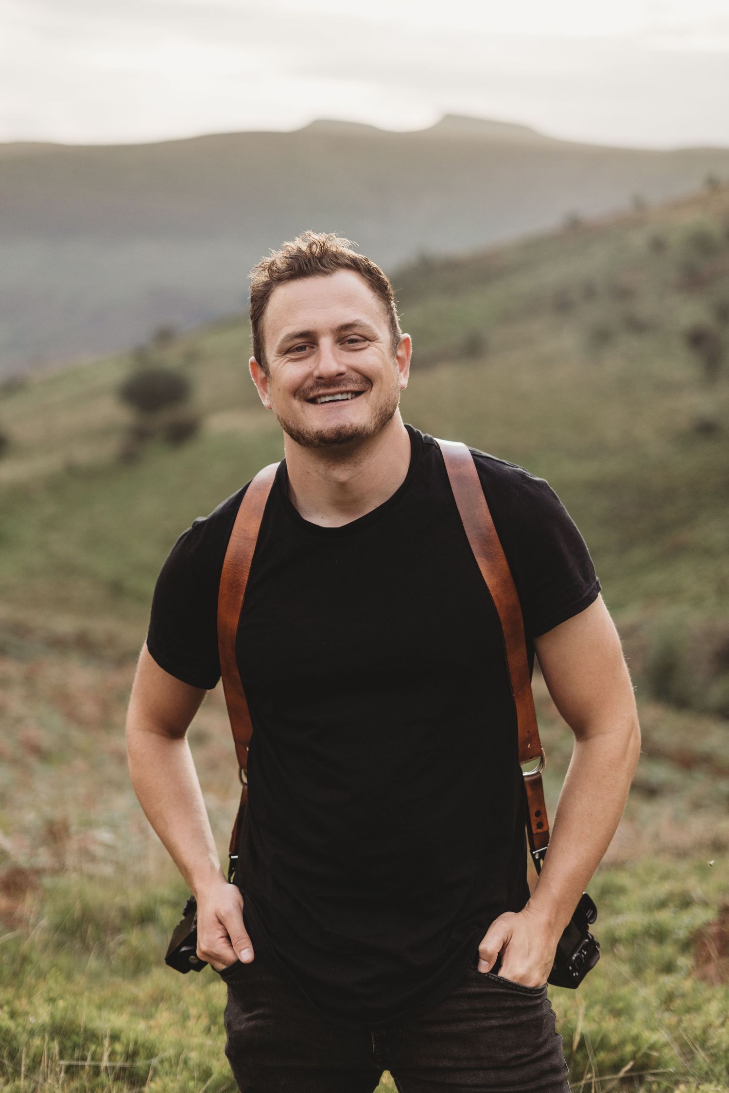 Wedding photographer standing in the Welsh countryside.