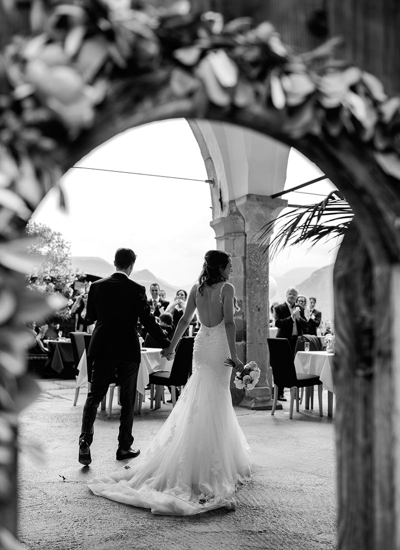 Bride and groom walking through historic wooden door during Dolomites destination wedding