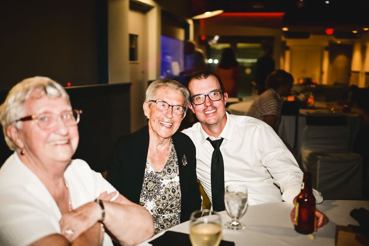 Grandmother, over ninety years old, laughing and celebrating with her adult grandchild at a wedding reception, Newfoundland.