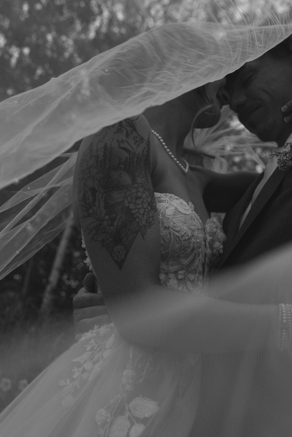 A series of black and white photos showing close-up details of a bridal veil and lace wedding dress.