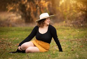 A series of outdoor autumn portraits in golden sunlight with mustard yellow dress and black top against fallen leaves.
