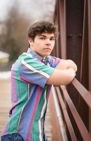 A child in a striped shirt and overalls leans against a wooden railing in a series of similar poses.