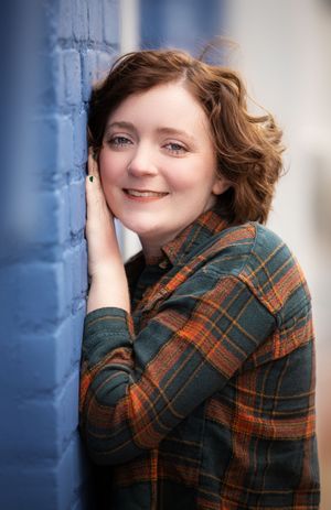 Portrait series against blue wall showing warm expressions in plaid flannel shirt.