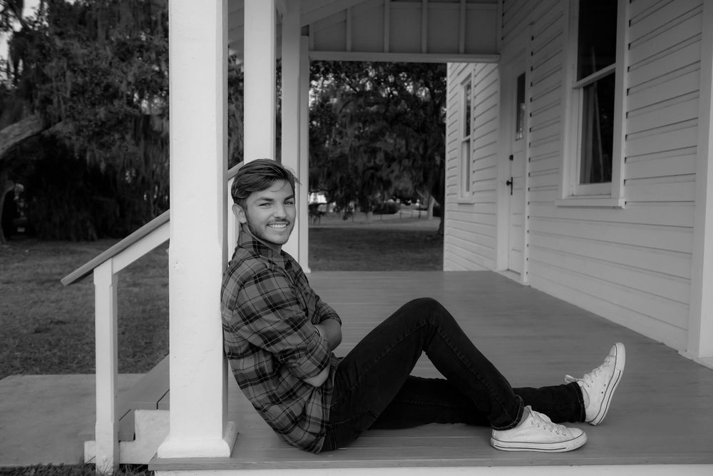 A series of five black and white photos showing someone sitting on a porch in different poses.