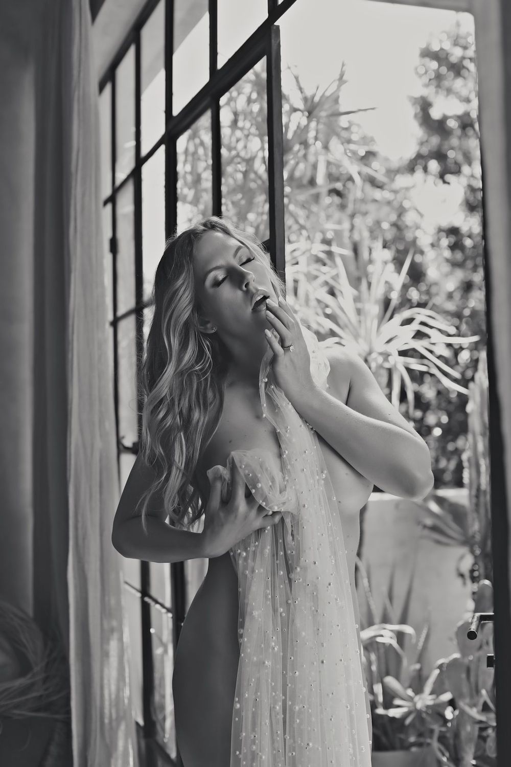 Black and white artistic photo series showing dramatic poses against window light and flowing fabric.