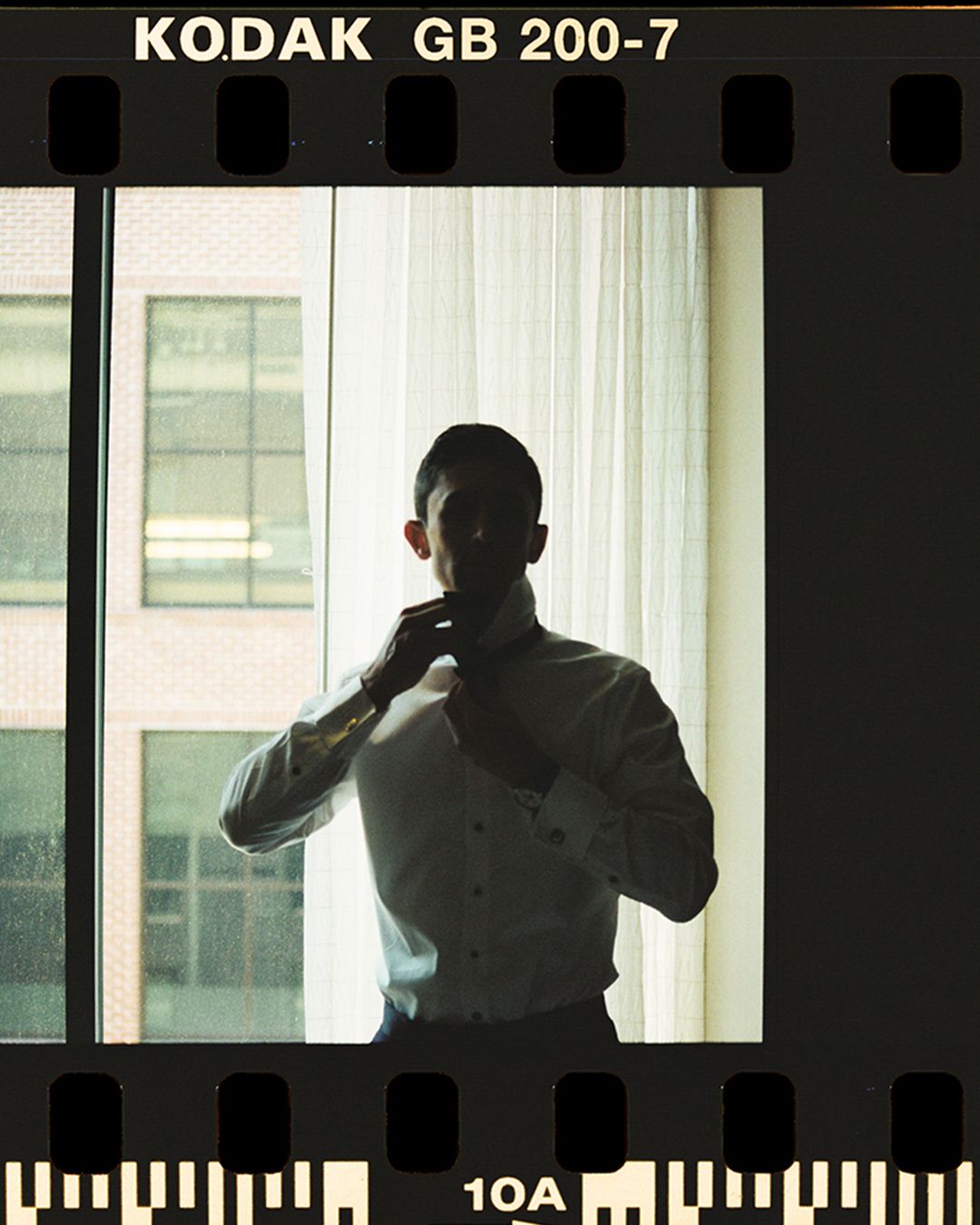Silhouettes of people standing against bright windows with Kodak GB 200-7 film branding visible at the top.